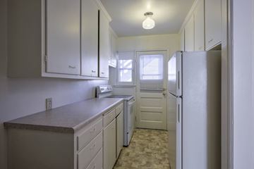 Omaha apartment for rent - A kitchen with white cabinets and a refrigerator.