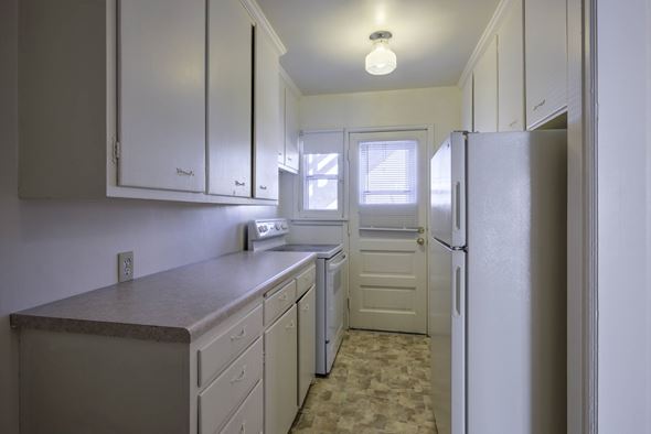 Omaha apartment for rent - A kitchen with white cabinets and a refrigerator.
