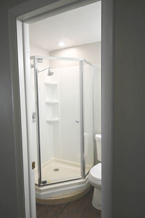 Omaha apartment for rent - A white toilet is in a bathroom with a walk-in shower.