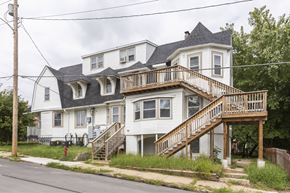 Omaha apartment for rent - A two-story house with a white exterior and a balcony on the second floor.