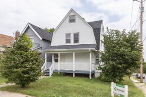 Omaha apartment for rent - A two-story house with a front porch and a sign that says