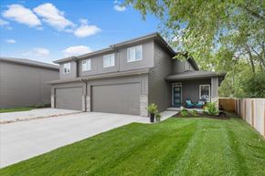 Omaha townhouse for rent - A house with a grey garage door and a blue door.