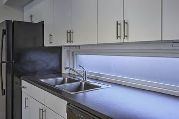 Council Bluffs apartment for rent - A kitchen with a black refrigerator and a stainless steel sink.