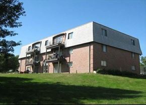Omaha apartment for rent - A red brick building with a white roof and a balcony on the second floor.