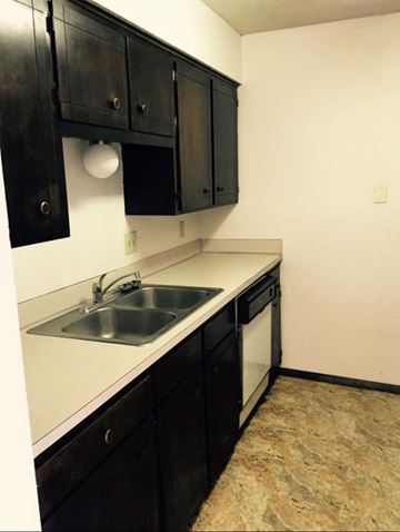 Omaha apartment for rent - A kitchen with black cabinets and a white counter top.