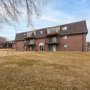 Omaha apartment for rent - A large brick building with a balcony on the second floor.