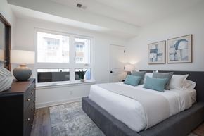 Carteret apartment for rent - A bedroom with a large bed and a window overlooking a building.