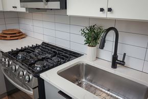 Carteret apartment for rent - A modern kitchen with a black gas stove and a stainless steel sink.
