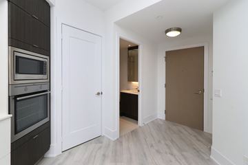 Toronto apartment for rent - A kitchen with a white door and a microwave above the oven.