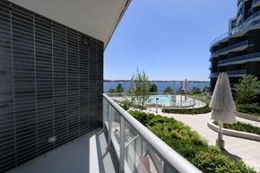 Toronto apartment for rent - A balcony with a pool and a view of the water.