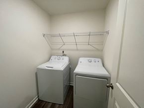 Wilson apartment for rent - Two white washing machines in a small laundry room.