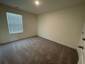 Wilson apartment for rent - A room with a carpeted floor and a window with blinds.