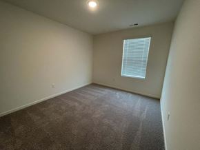 Wilson apartment for rent - A room with a carpeted floor and a window with blinds.