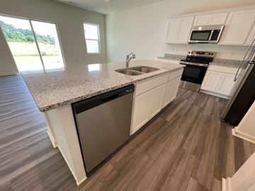Wilson apartment for rent - A kitchen with white cabinets and a granite countertop.