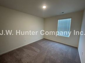 Wilson apartment for rent - A room with a carpeted floor and a window with blinds.