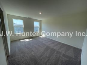 Wilson apartment for rent - A carpeted room with a window and a J.W. Hunter Company Inc. logo.