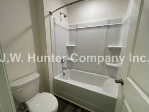 Wilson apartment for rent - A white toilet and sink in a small bathroom.