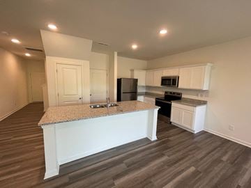 Wilson apartment for rent - A kitchen with a granite countertop and white cabinets.