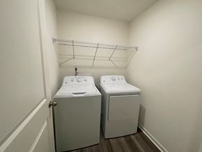 Wilson apartment for rent - Two white washing machines in a small laundry room.