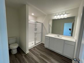 Wilson apartment for rent - A bathroom with a toilet, sink, and shower.