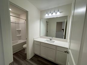 Wilson apartment for rent - A white bathroom with a toilet, sink, and mirror.