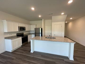 Wilson apartment for rent - A kitchen with a granite countertop and white cabinets.