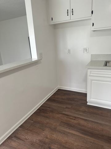 Westminster apartment for rent - A kitchen with white cabinets and a wooden floor.