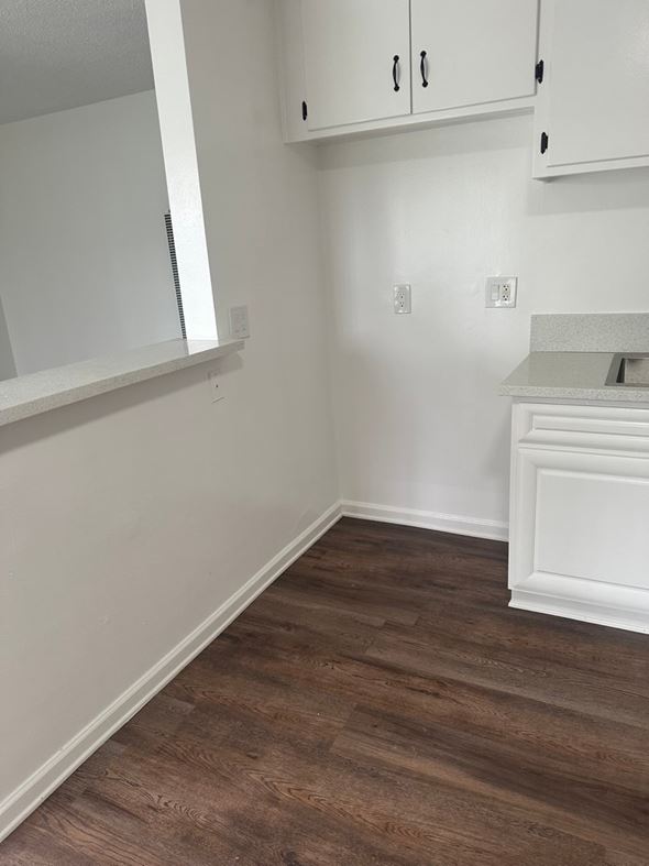 Westminster apartment for rent - A kitchen with white cabinets and a wooden floor.