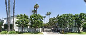 Westminster apartment for rent - A white building with a gate and trees in front.