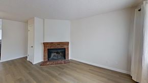 Edgewater house for rent - A room with a fireplace and wooden floors.