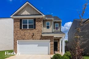 Newnan house for rent - A house with a garage door and a brick wall.