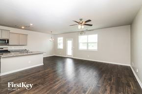 Newnan house for rent - A spacious room with wooden floors and a ceiling fan.