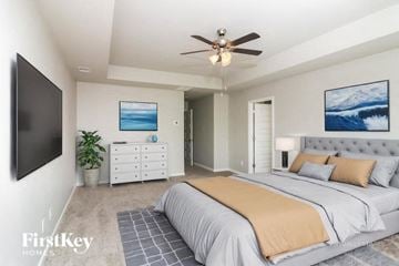Newnan house for rent - A bedroom with a large bed and a ceiling fan.