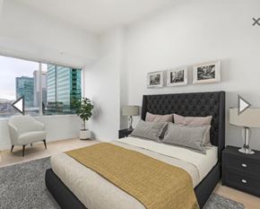 Edmonton apartment for rent - A bedroom with a large bed and a chair by the window.