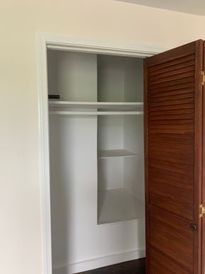 Lindale house for rent - A white door with a shelf and a brown door.