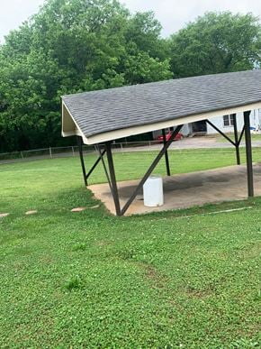 Lindale house for rent - A white metal pole with a black roof is in the grass.