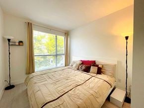 Vancouver apartment for rent - A bedroom with a large bed and a window with curtains.