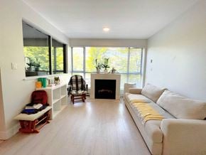 Vancouver apartment for rent - A living room with a fireplace, couch, and a chair.