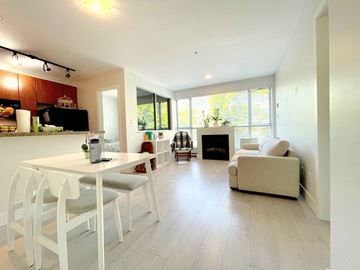 Vancouver apartment for rent - A modern kitchen with white chairs and a dining table.