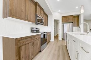 Beaumont apartment for rent - A kitchen with wooden cabinets and white countertops.