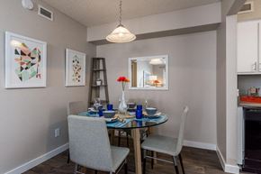 Phoenix apartment for rent - A dining room with a table set for two and a chandelier hanging from the ceiling.