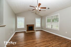 Covington house for rent - A spacious room with a fireplace and a ceiling fan.