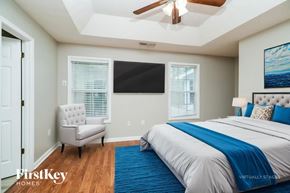 Covington house for rent - A bedroom with a bed, chair, and ceiling fan.