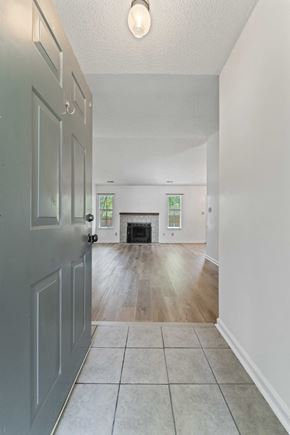 Midway Park house for rent - A hallway with a grey door and a tiled floor.