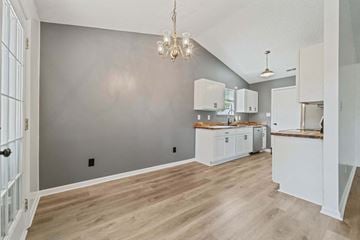 Midway Park house for rent - A kitchen with white cabinets and a wooden floor.
