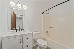 Midway Park house for rent - A white bathroom with a toilet, sink, and bathtub.