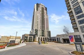 Toronto apartment for rent - A tall building with many windows stands in front of a smaller building with a colorful mural.