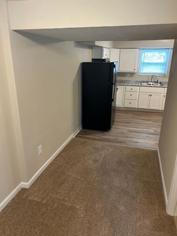 Elsmere house for rent - A black refrigerator in a kitchen with white cabinets.