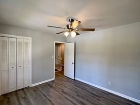 Rome house for rent - A room with a ceiling fan and wooden floors.
