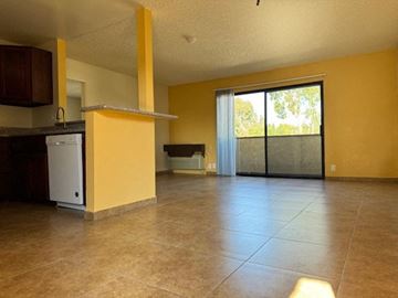 Van Nuys apartment for rent - A yellow kitchen with a white dishwasher and a black fridge.